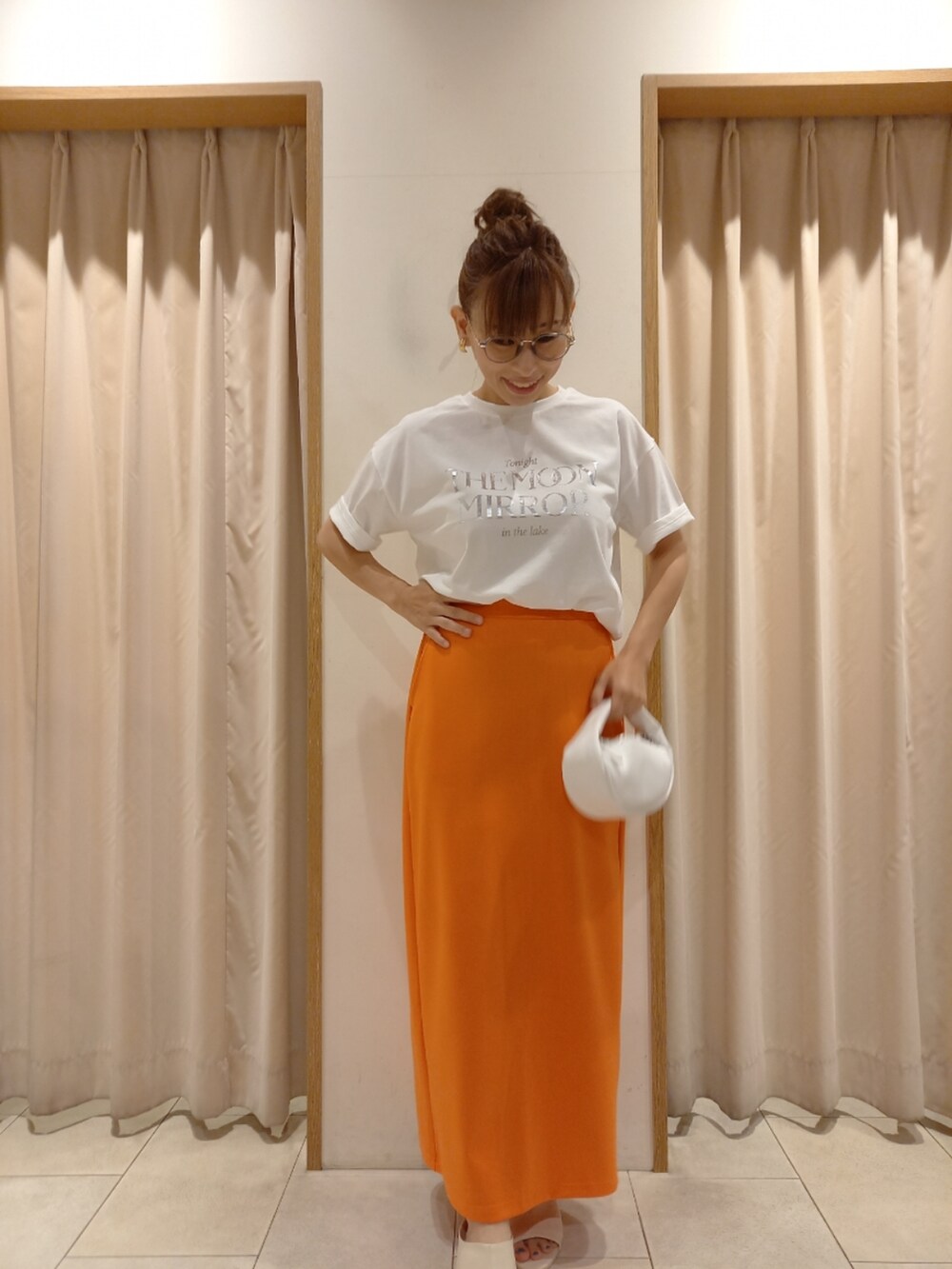 ホワイト系のTシャツ/カットソー、オレンジ系のスカートを着用したレディースの夏コーディネートの2枚目の写真