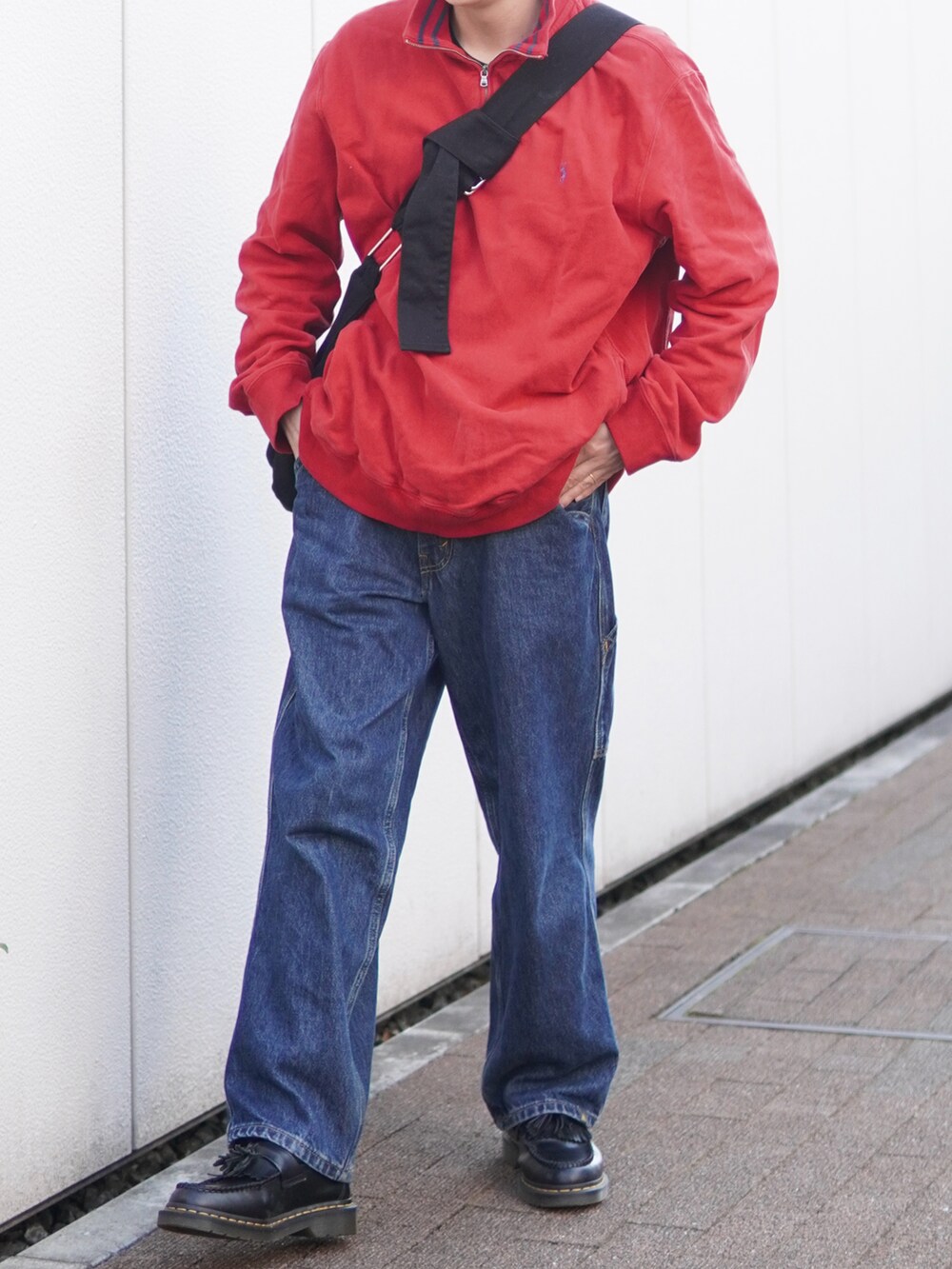 ブルー系のデニムパンツ、ブラック系のローファー、レッド系のスウェットを着用したメンズの春コーディネートの3枚目の写真