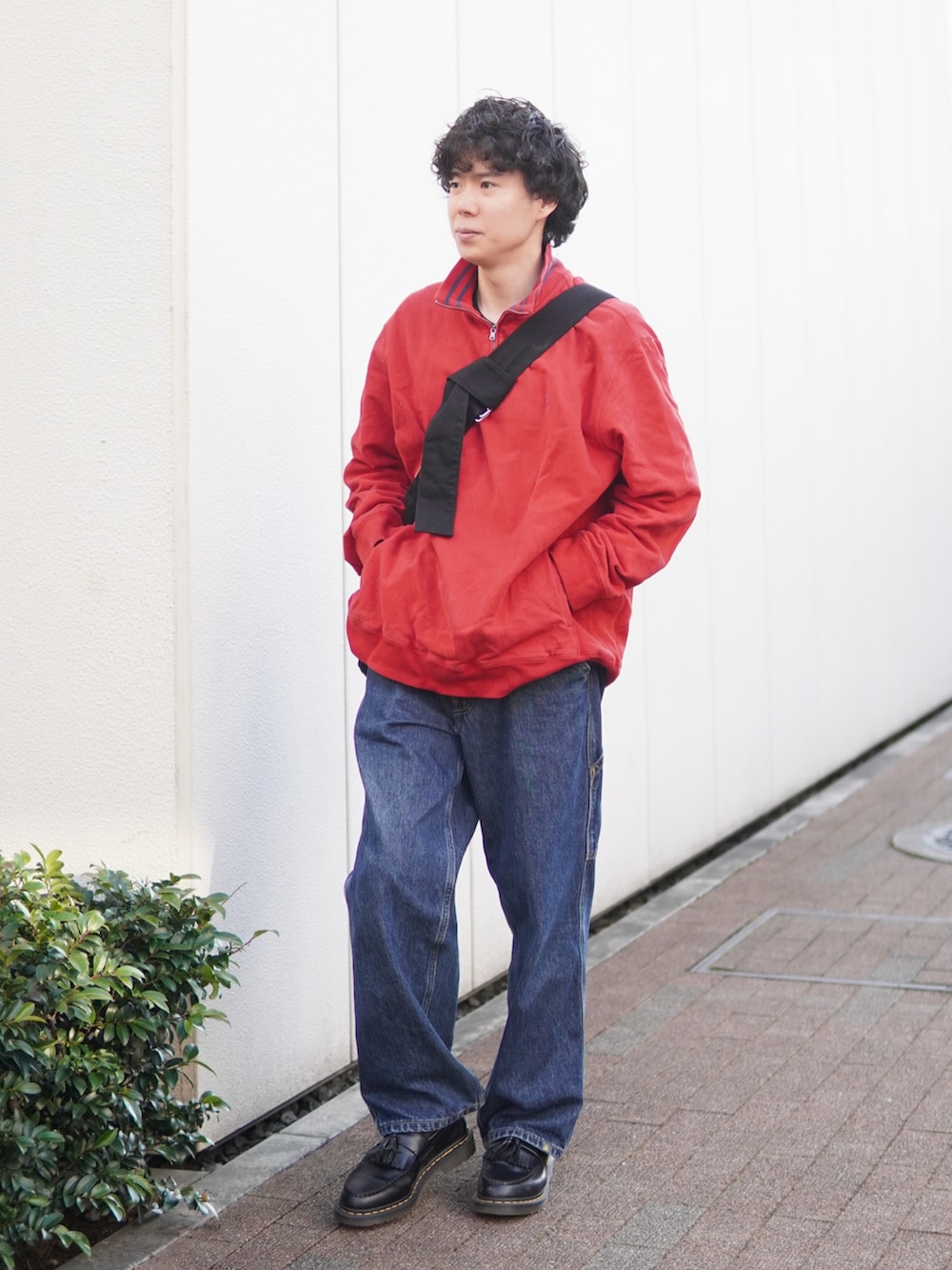 ブルー系のデニムパンツ、ブラック系のローファー、レッド系のスウェットを着用したメンズの春コーディネートの2枚目の写真