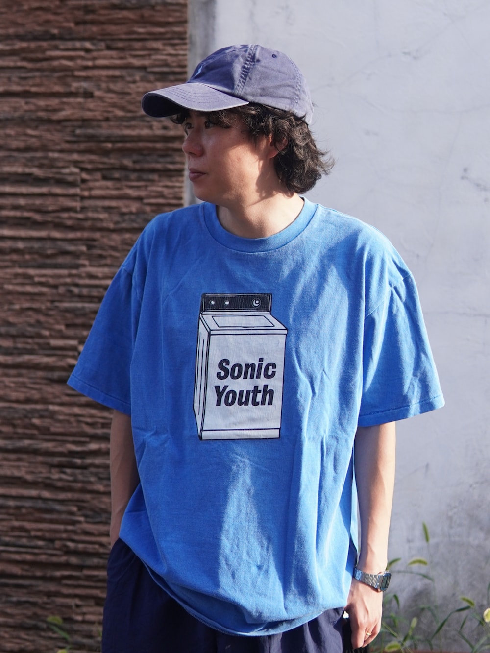 ブラック系のハンドバッグ、ブラウン系のスニーカー、ブルー系のTシャツ/カットソーを着用したメンズの秋コーディネートの3枚目の写真