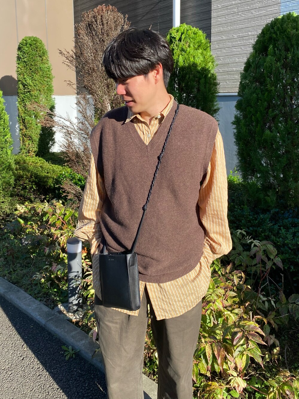 「重ね着ベストシーズン、ベスト、レイヤードスタイル、ストライプシャツ、ブラウン、プチプラ、きれいめカジュアル、ミニバッグ、ショルダーバッグ、秋コーデ、お出かけコーデ、ニット、ビッグシルエット、ゆるコーデ、UNIQLO」｜「UNIQLOのアイテム（パンツ、グリーン系）」を使った、しゅんたさん（メンズ・172cm）の秋コーディネートの2枚目の写真