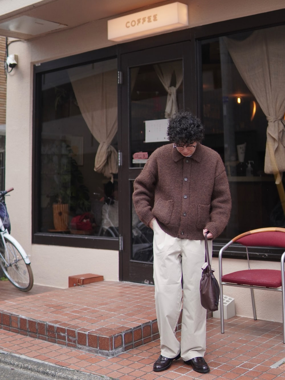 ベージュ系のチノパンツ、ブラウン系のカーディガン/ボレロ、ブラウン系のショルダーバッグを着用したメンズの冬コーディネートの3枚目の写真