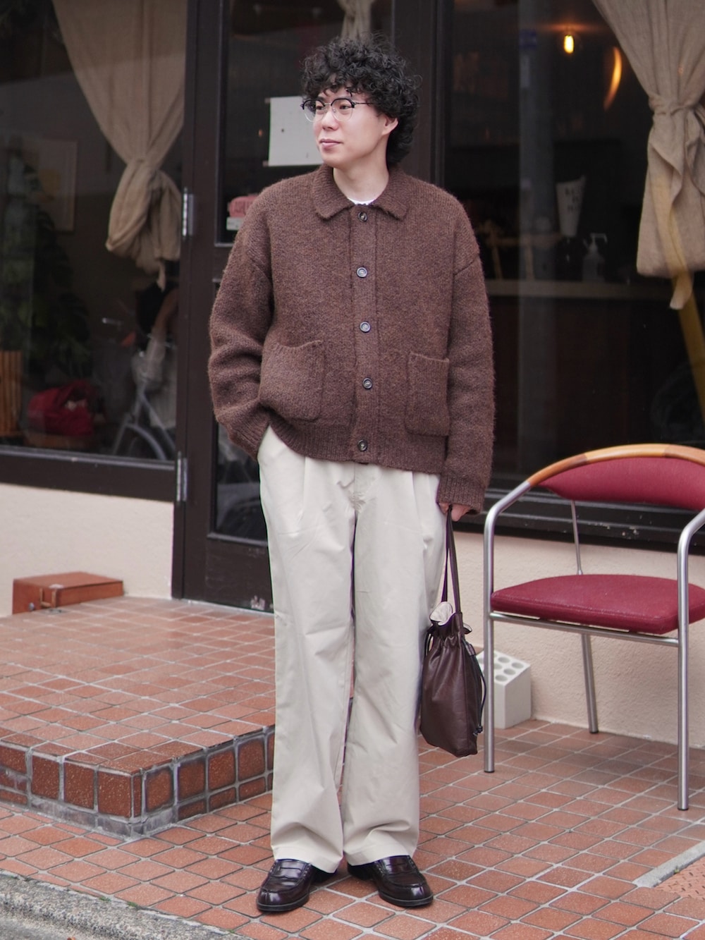 ベージュ系のチノパンツ、ブラウン系のカーディガン/ボレロ、ブラウン系のショルダーバッグを着用したメンズの冬コーディネートの2枚目の写真