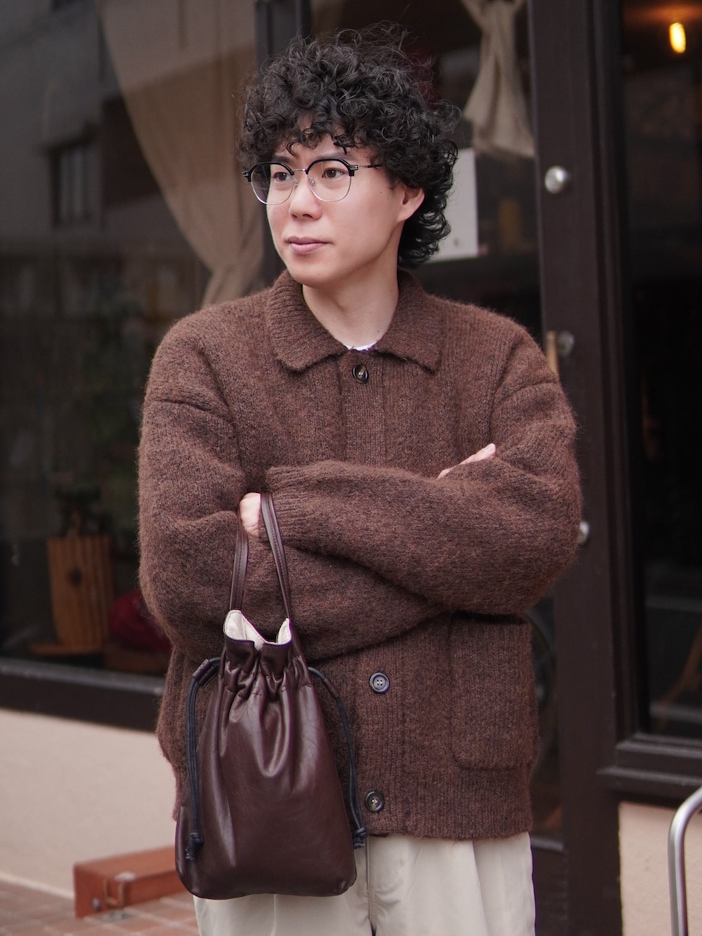 ベージュ系のチノパンツ、ブラウン系のカーディガン/ボレロ、ブラウン系のショルダーバッグを着用したメンズの冬コーディネートの4枚目の写真