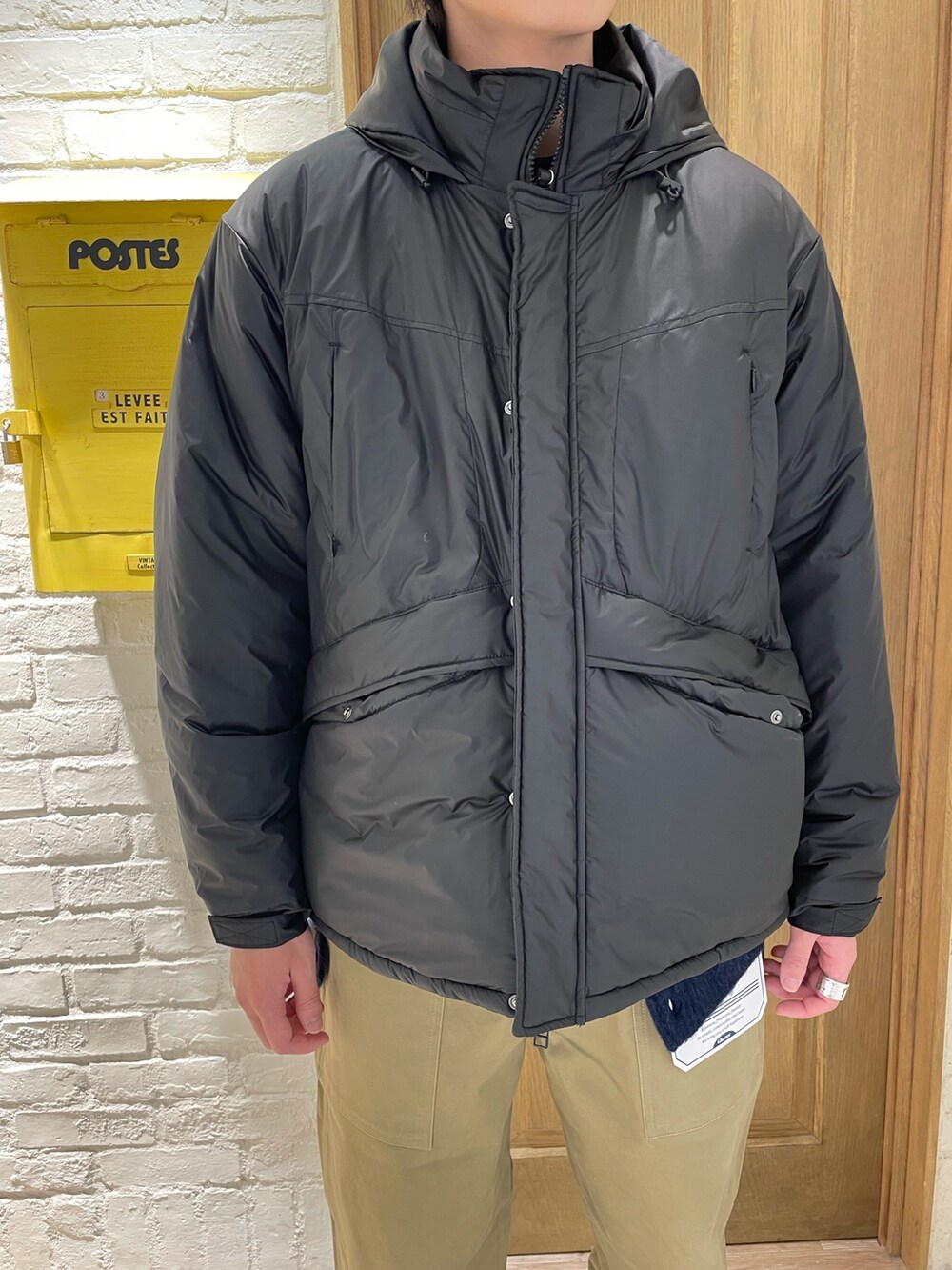 ベージュ系のその他パンツ、ブラック系のダウンジャケット/コートを着用したメンズの冬コーディネートの2枚目の写真