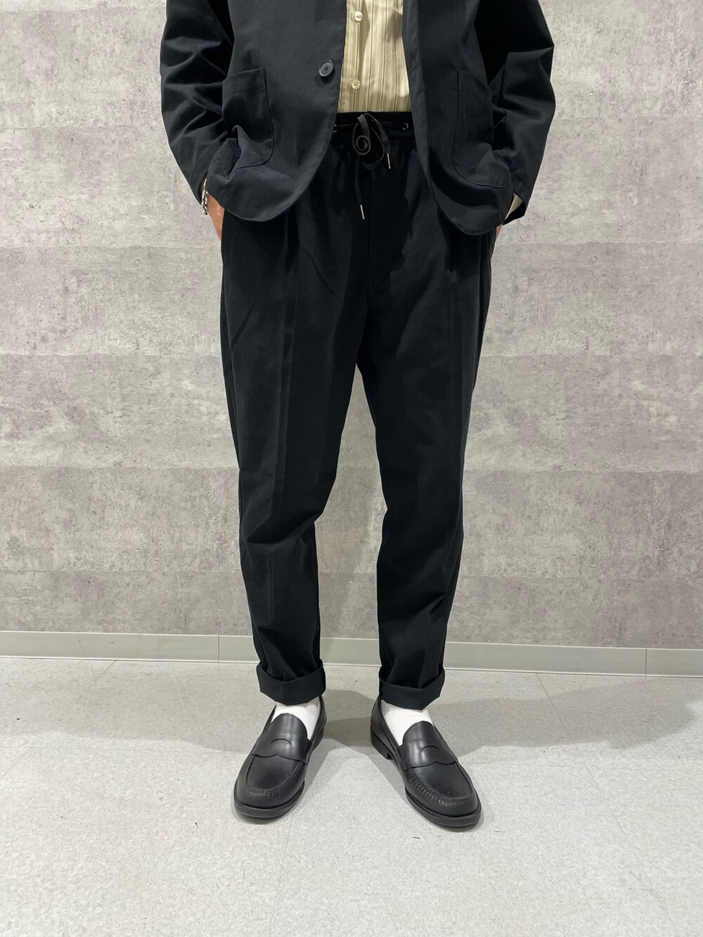 ブラック系のテーラードジャケット、ベージュ系のシャツ/ブラウス、ブラック系のその他パンツを着用したメンズの秋コーディネートの3枚目の写真