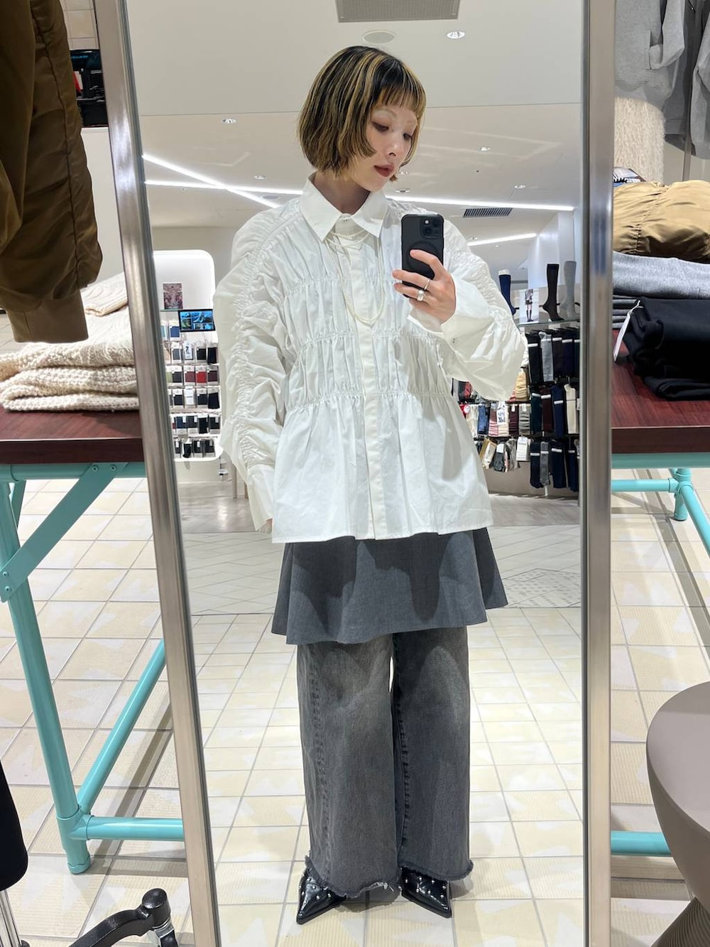 ブラック系のデニムパンツ、グレー系のワンピース、ホワイト系のシャツ/ブラウスを着用したレディースの秋コーディネートの2枚目の写真
