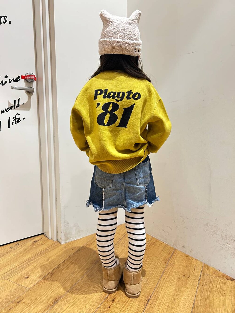 ベージュ系のブーツ、ブルー系のデニムスカート、イエロー系のニット/セーターを着用したキッズの冬コーディネートの2枚目の写真