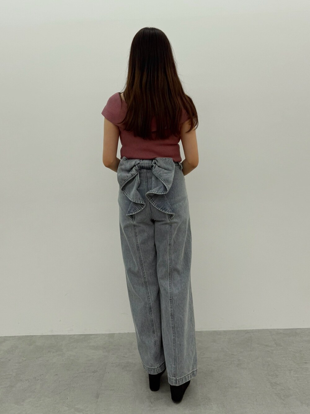 ピンク系のニット/セーター、ブルー系のデニムパンツ、ブラック系のサンダルを着用したレディースの春コーディネートの3枚目の写真