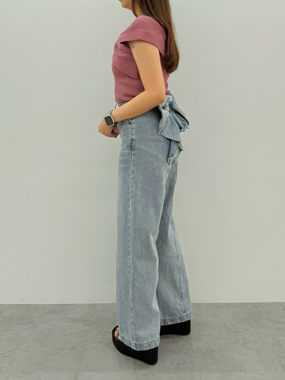 ピンク系のニット/セーター、ブルー系のデニムパンツ、ブラック系のサンダルを着用したレディースの春コーディネートの2枚目の写真