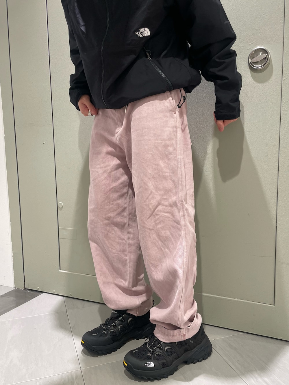 ブラック系のマウンテンパーカー、ピンク系のその他パンツ、ブラック系のスニーカーを着用したメンズの春コーディネートの3枚目の写真