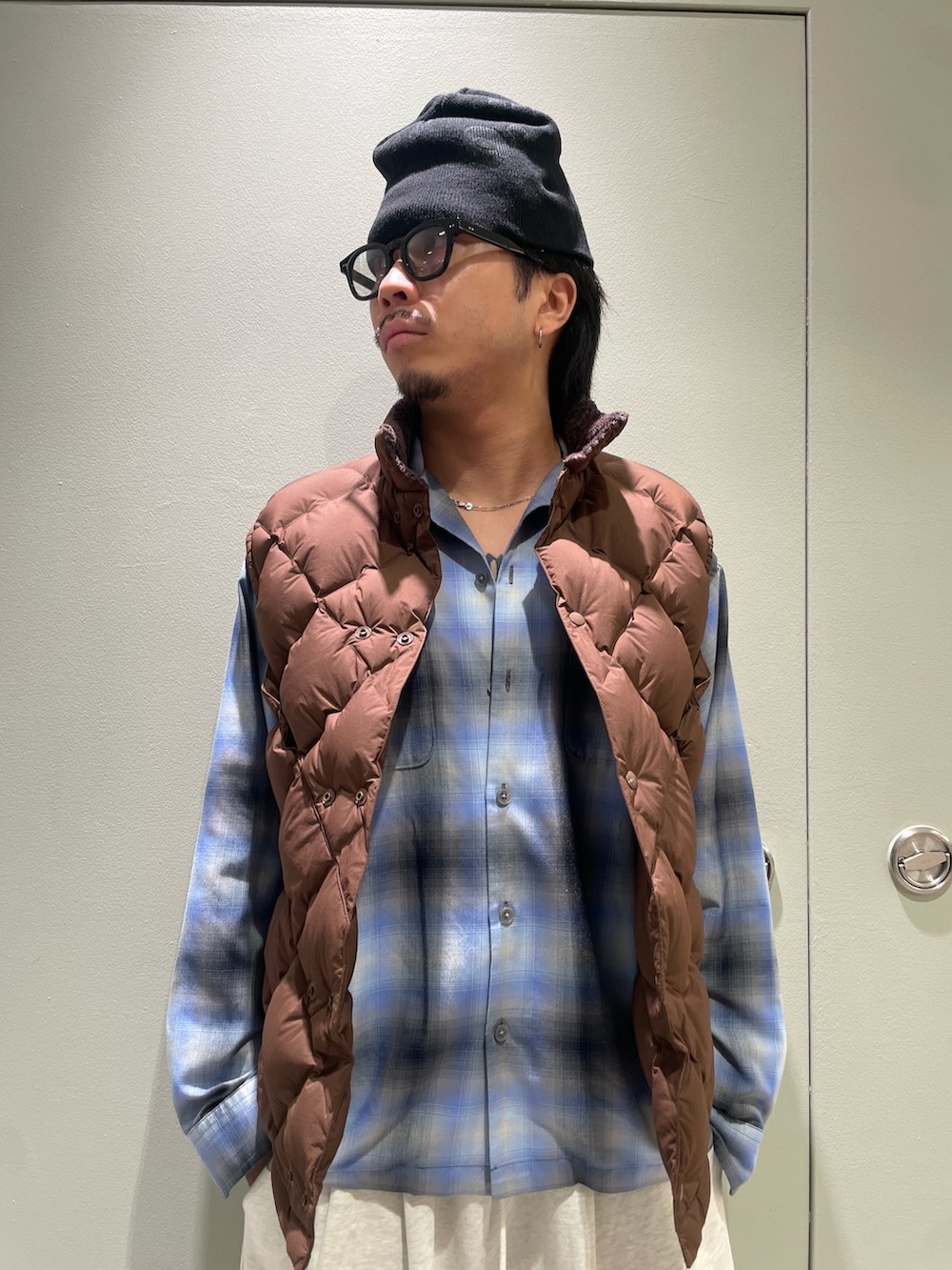 ブルー系のシャツ/ブラウス、ブラウン系のダウンベストを着用したメンズの秋コーディネートの2枚目の写真