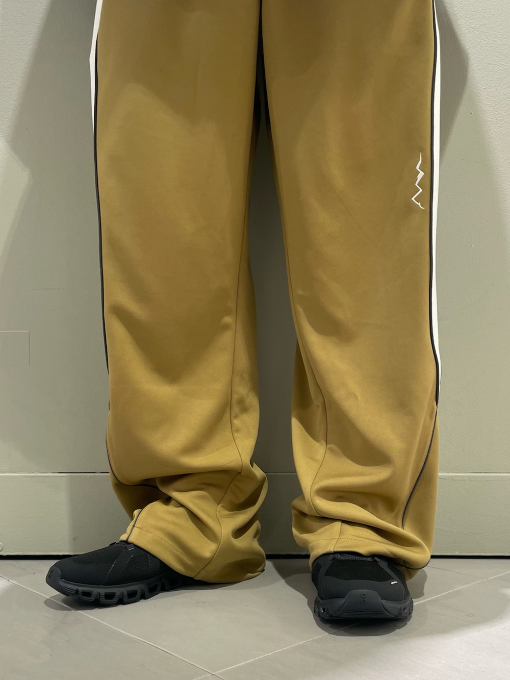 ホワイト系のスニーカー、ブラック系のブルゾン、ブラック系のショルダーバッグを着用したメンズの春コーディネートの3枚目の写真