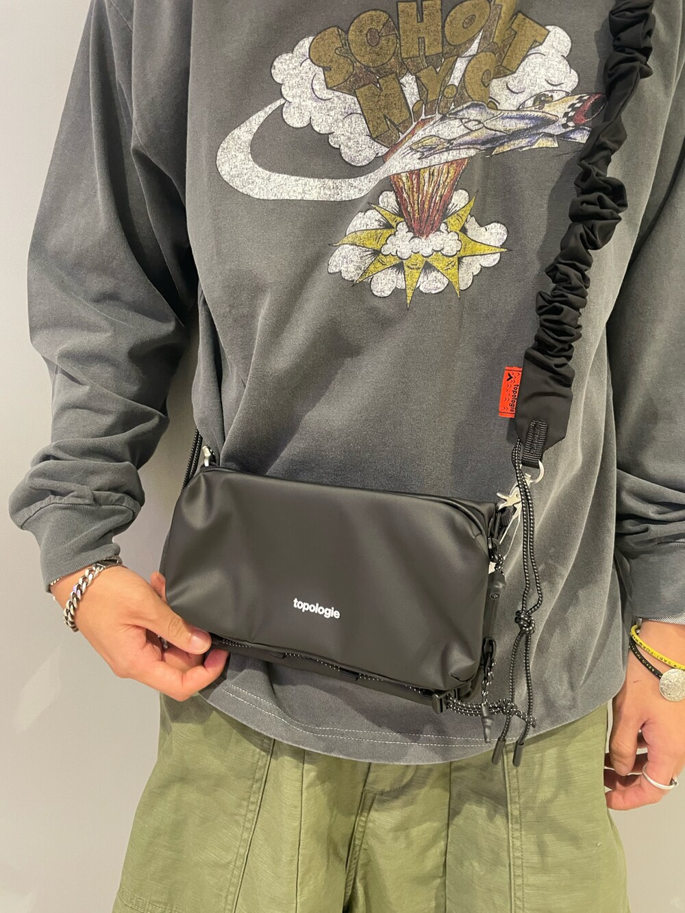 ブラック系のTシャツ/カットソー、ブラック系のスマホグッズを着用したメンズの夏コーディネートの2枚目の写真
