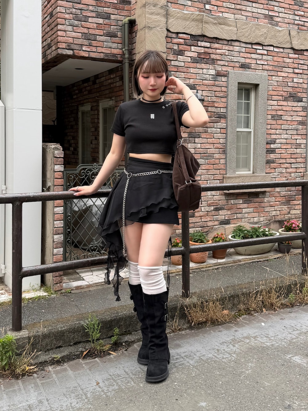 ブラウン系のショルダーバッグ、ブラック系のスカート、ブラック系のTシャツ/カットソーを着用したレディースの夏コーディネートの2枚目の写真