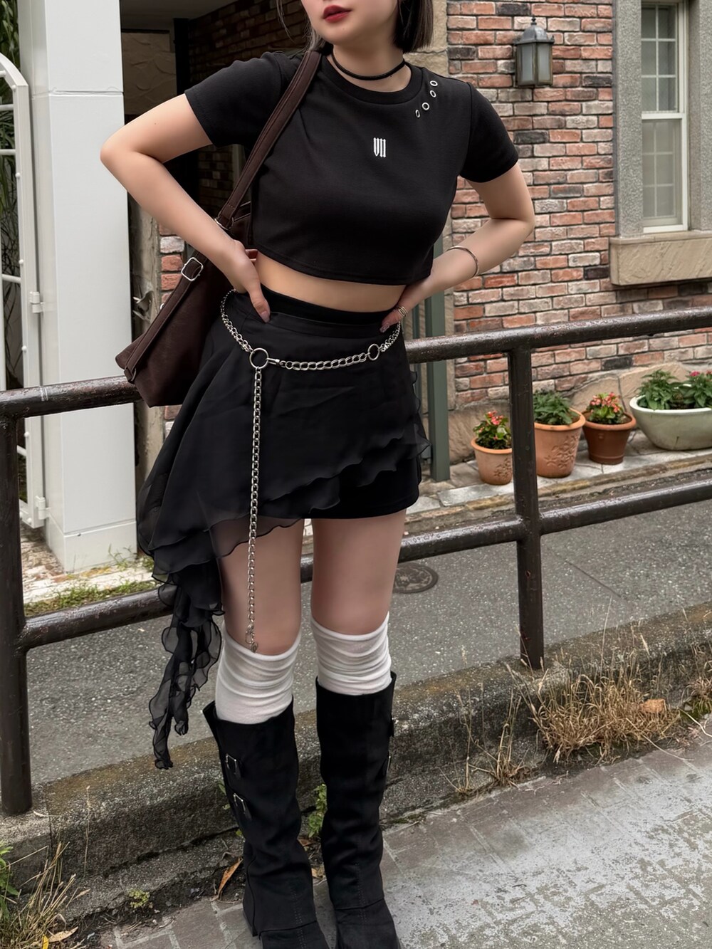 ブラウン系のショルダーバッグ、ブラック系のスカート、ブラック系のTシャツ/カットソーを着用したレディースの夏コーディネートの4枚目の写真