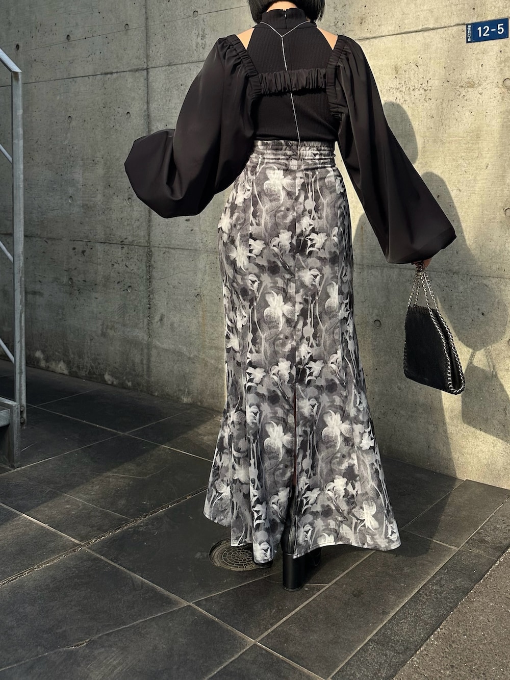 グレー系のスカート、ブラック系のカーディガン/ボレロ、ブラック系のキャミソールを着用したレディースの春コーディネートの3枚目の写真