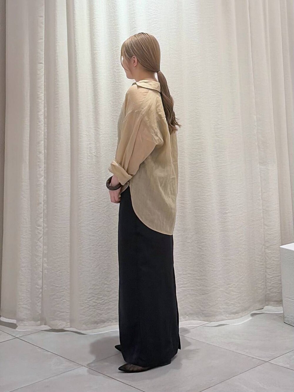 ブラック系のパンプス、ベージュ系のシャツ/ブラウス、ブラック系のスカートを着用したレディースの春コーディネートの3枚目の写真
