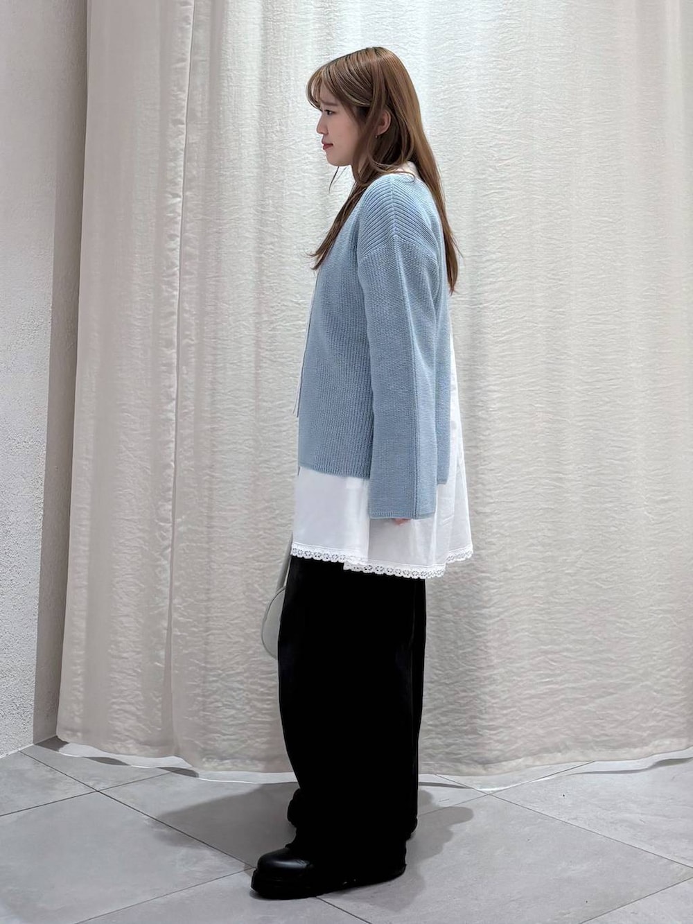 ブラック系のデニムパンツ、ブラック系のブーツ、ホワイト系のシャツ/ブラウスを着用したレディースの冬コーディネートの3枚目の写真