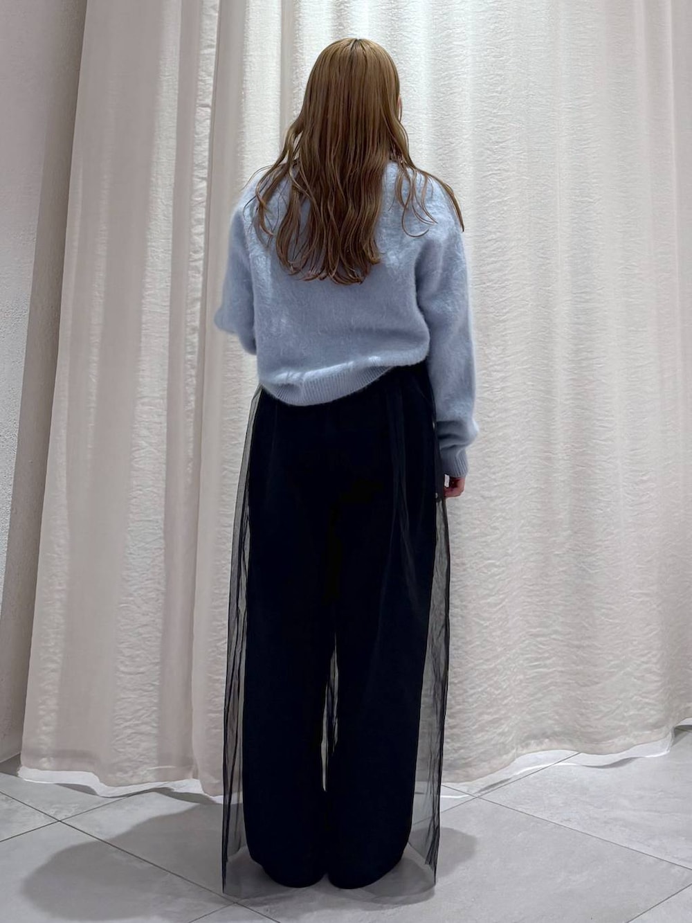 ブルー系のニット/セーター、シルバー系のスニーカー、ブラック系のその他パンツを着用したレディースの秋コーディネートの2枚目の写真