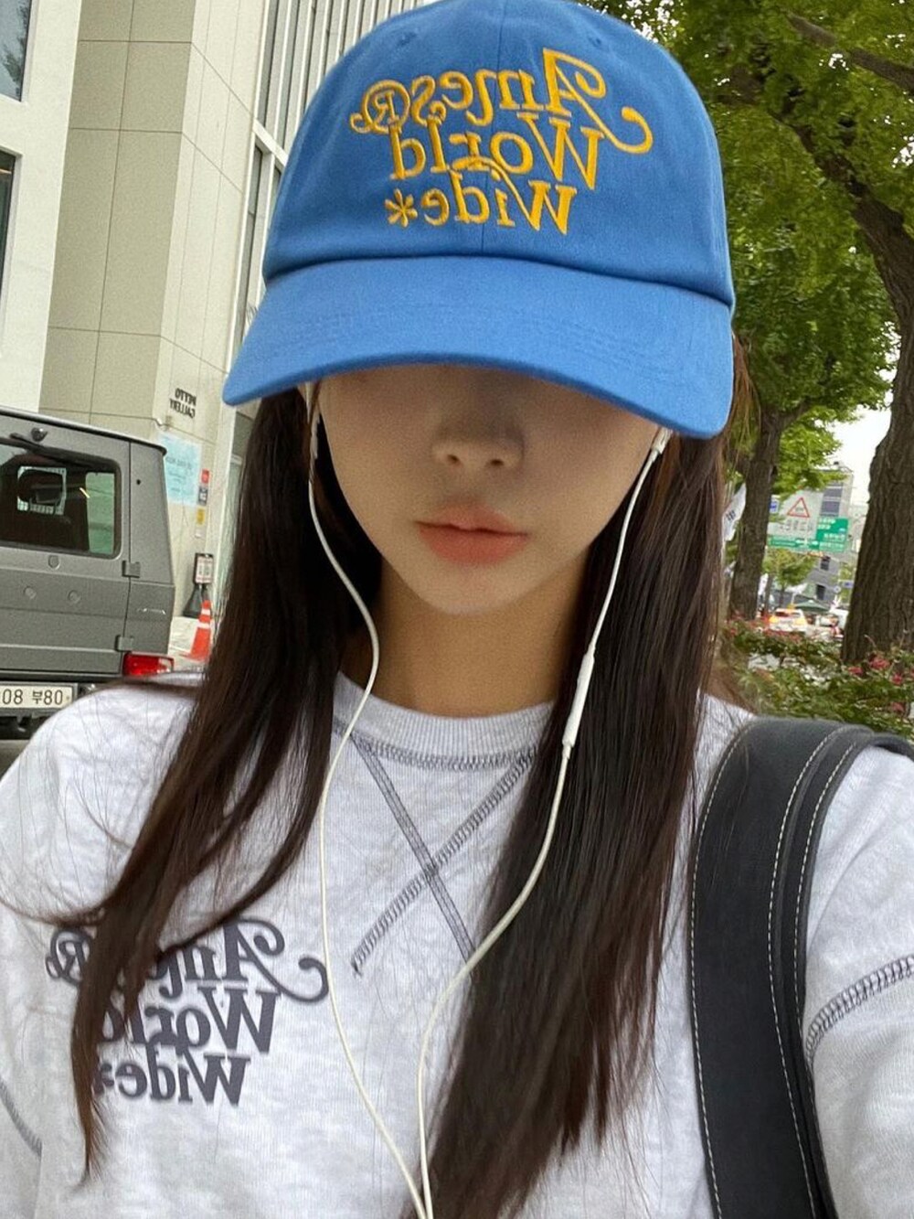 グレー系のスウェット、ブルー系のキャップを着用したレディースの秋コーディネートの2枚目の写真