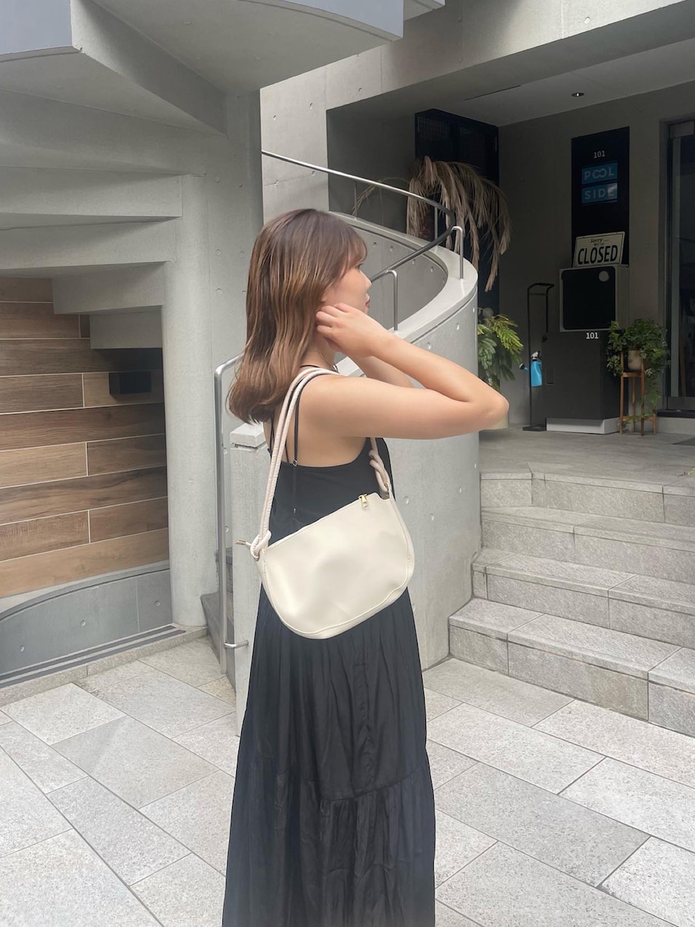 ブラック系のワンピース、ブルー系のキャップを着用したレディースの夏コーディネートの3枚目の写真