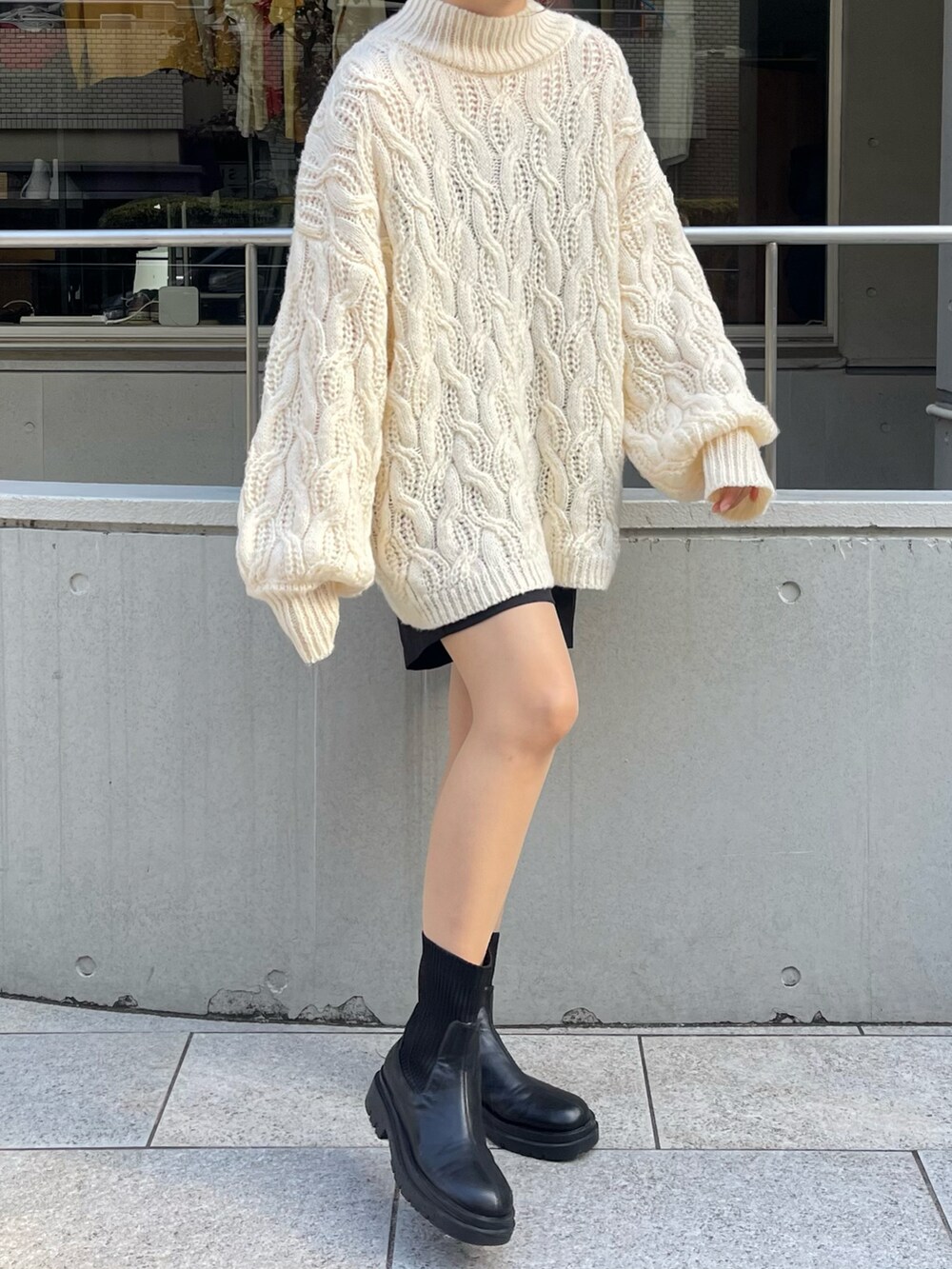 ホワイト系のニット/セーター、ブラック系のブーツを着用したレディースの秋コーディネートの3枚目の写真
