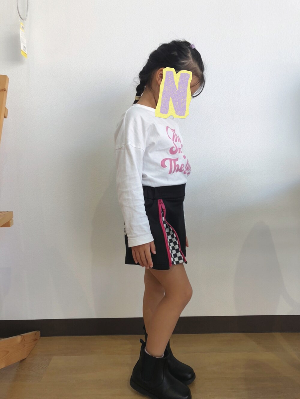 ホワイト系のTシャツ/カットソー、ブラック系のスカート、ブラック系のブーツを着用したキッズの秋コーディネートの3枚目の写真