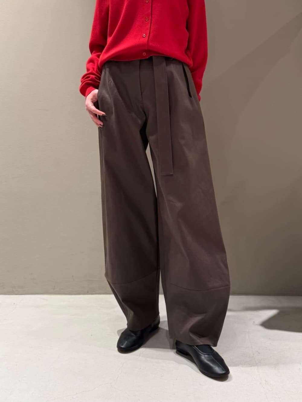 レッド系のカーディガン/ボレロ、ブラック系のニット/セーター、ブラウン系のその他パンツを着用したレディースの秋コーディネートの3枚目の写真