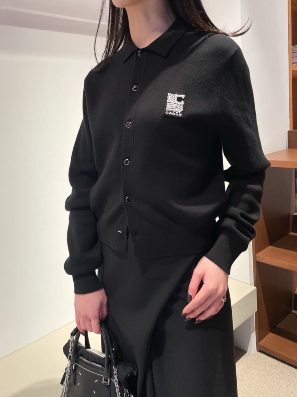 「TOMORROWLAND、トゥモローランド、caban、Edition、BACCA、ポロニット、ニットポロ、カーディガン、ジレ、ラップスカート、ロングスカート、モノトーン、大人カジュアル」｜「cabanのCABaN コットンカシミヤ パールロゴポロカーディガン（カーディガン/ボレロ、ブラック系）」を使った、Shimakawa_TOMORROWLANDさん（レディース・163cm）の冬コーディネートの2枚目の写真