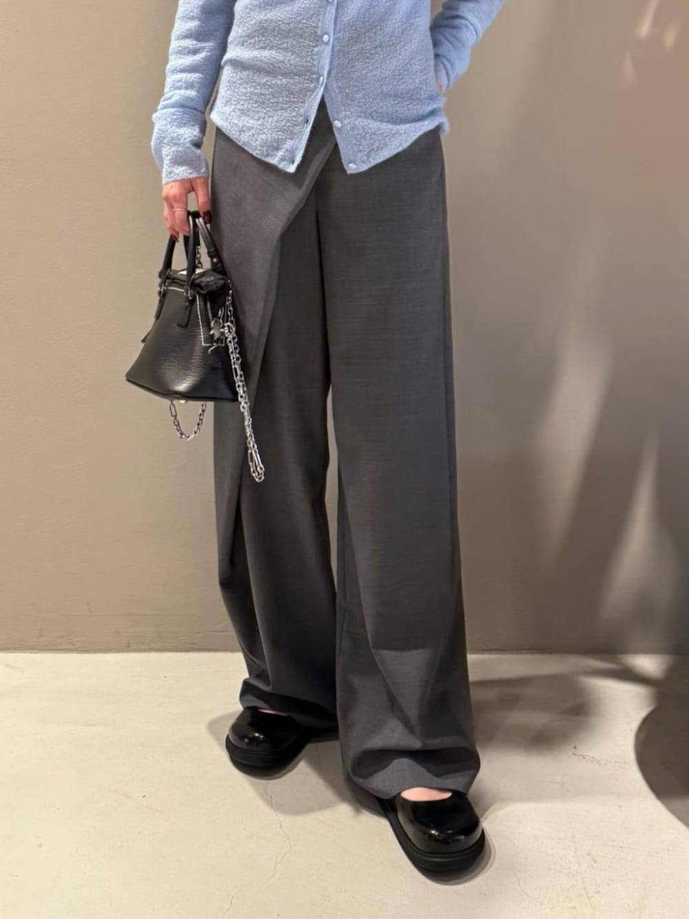 グレー系のスラックス、ブルー系のカーディガン/ボレロ、ブルー系のニット/セーターを着用したレディースの秋コーディネートの4枚目の写真