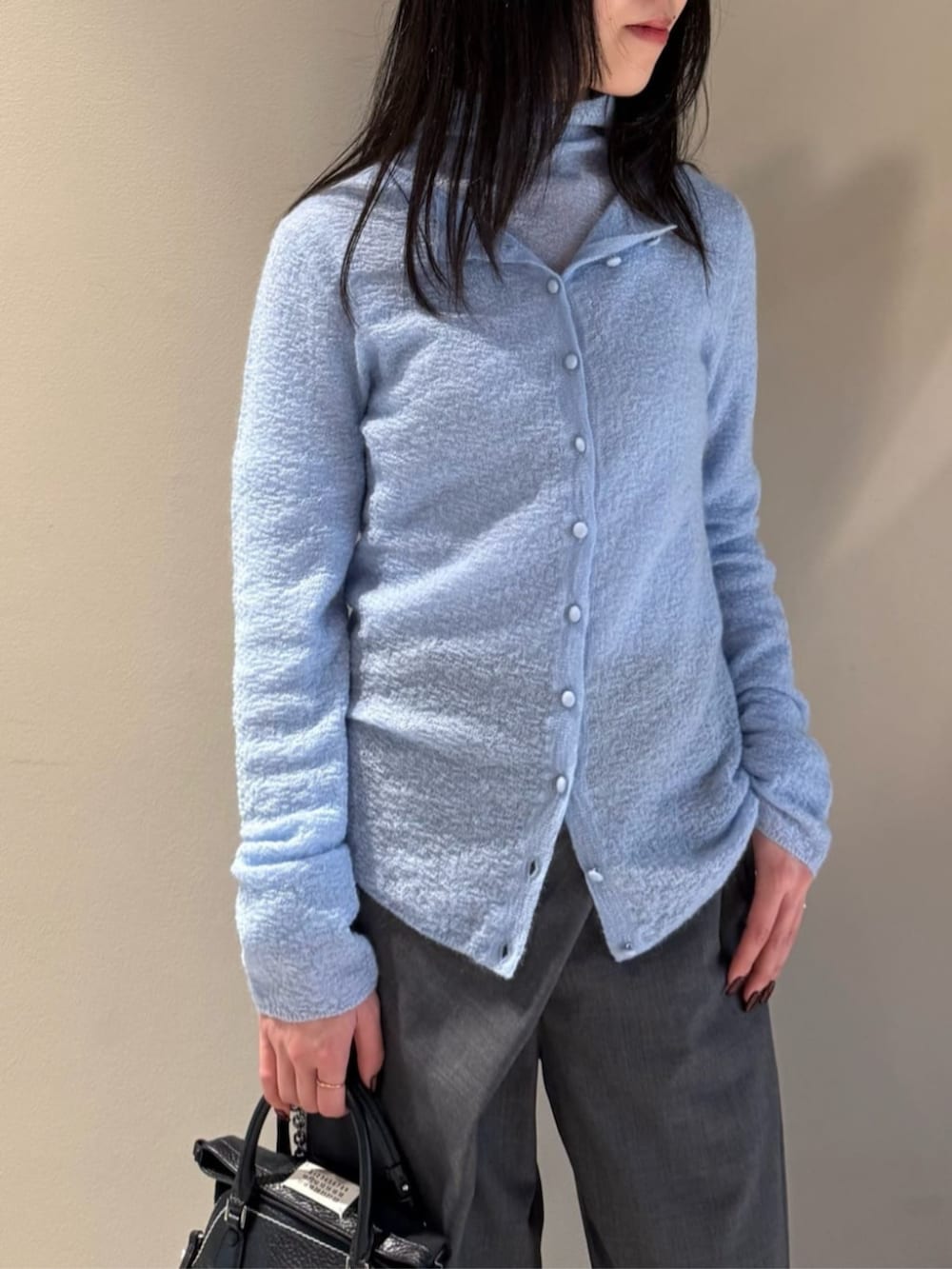 グレー系のスラックス、ブルー系のカーディガン/ボレロ、ブルー系のニット/セーターを着用したレディースの秋コーディネートの2枚目の写真