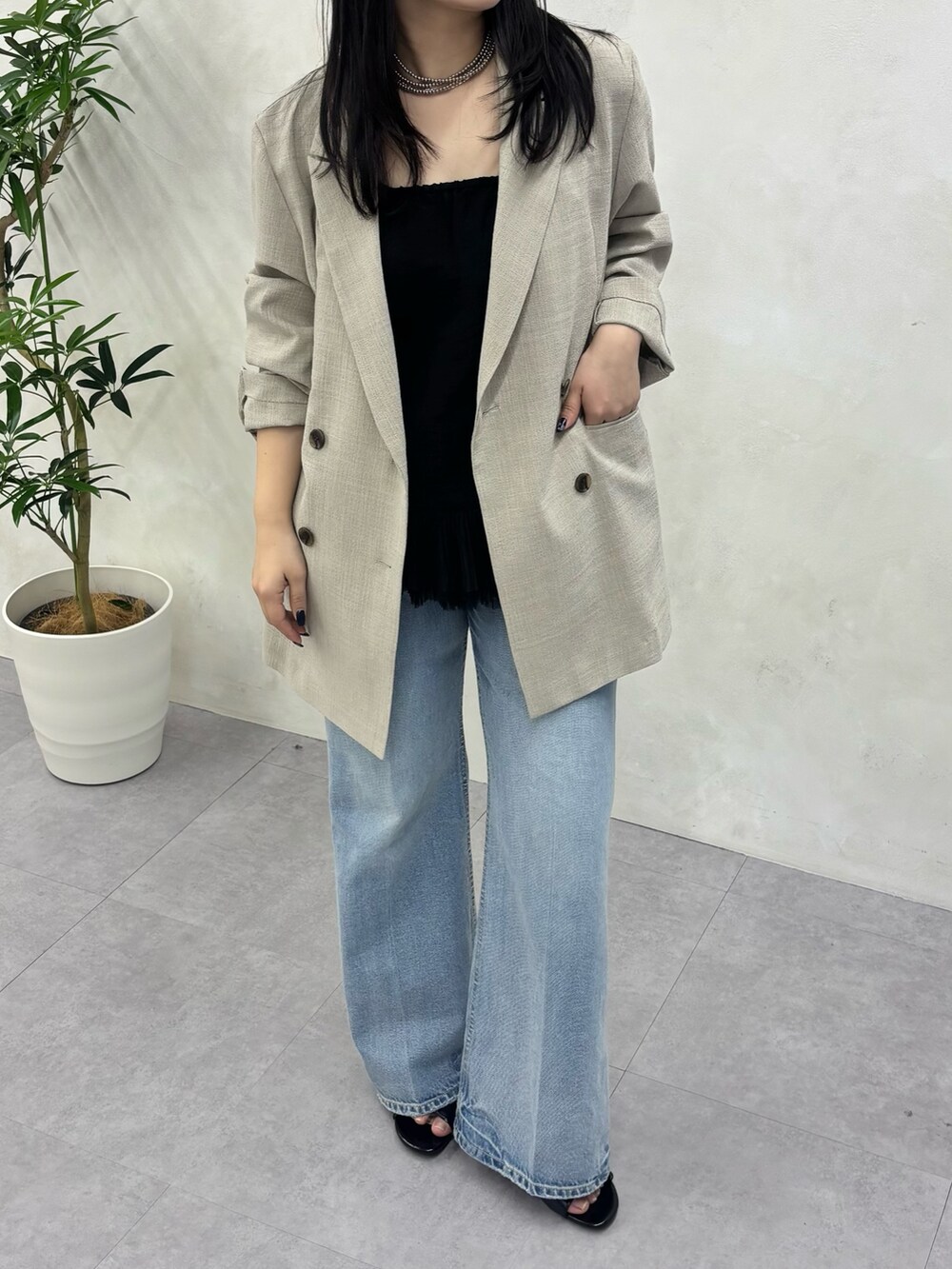 ベージュ系のテーラードジャケット、ブルー系のデニムパンツ、ブラック系のシャツ/ブラウスを着用したレディースの冬コーディネートの6枚目の写真