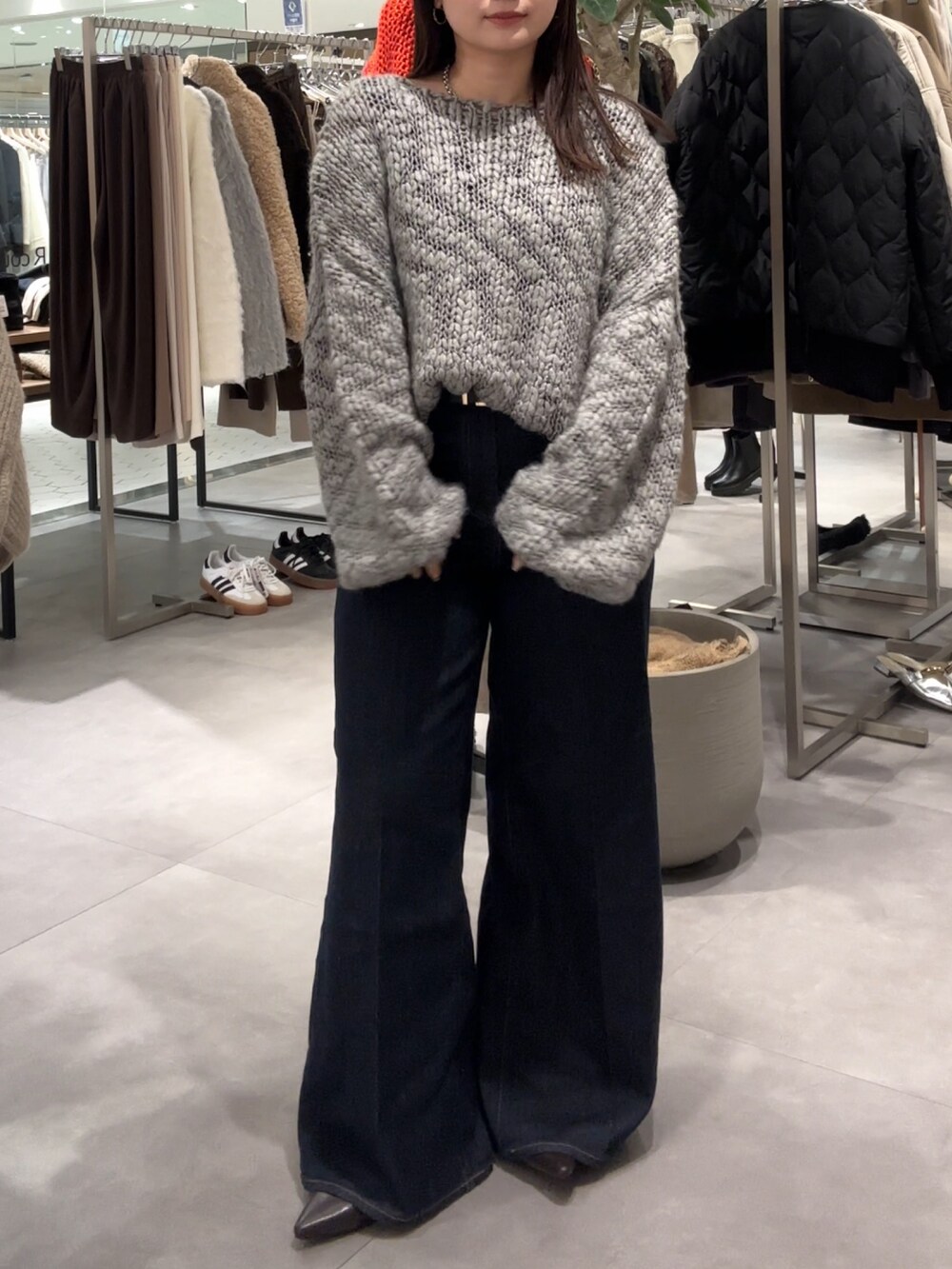 グレー系のニット/セーター、ブラウン系のパンプス、ホワイト系のシャツ/ブラウスを着用したレディースの冬コーディネートの3枚目の写真