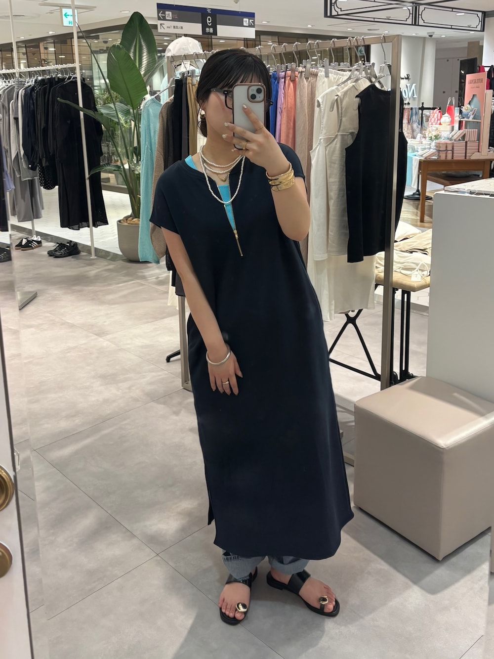 ブルー系のワンピース、ブルー系のデニムパンツ、ブラック系のサンダルを着用したレディースの春コーディネートの5枚目の写真