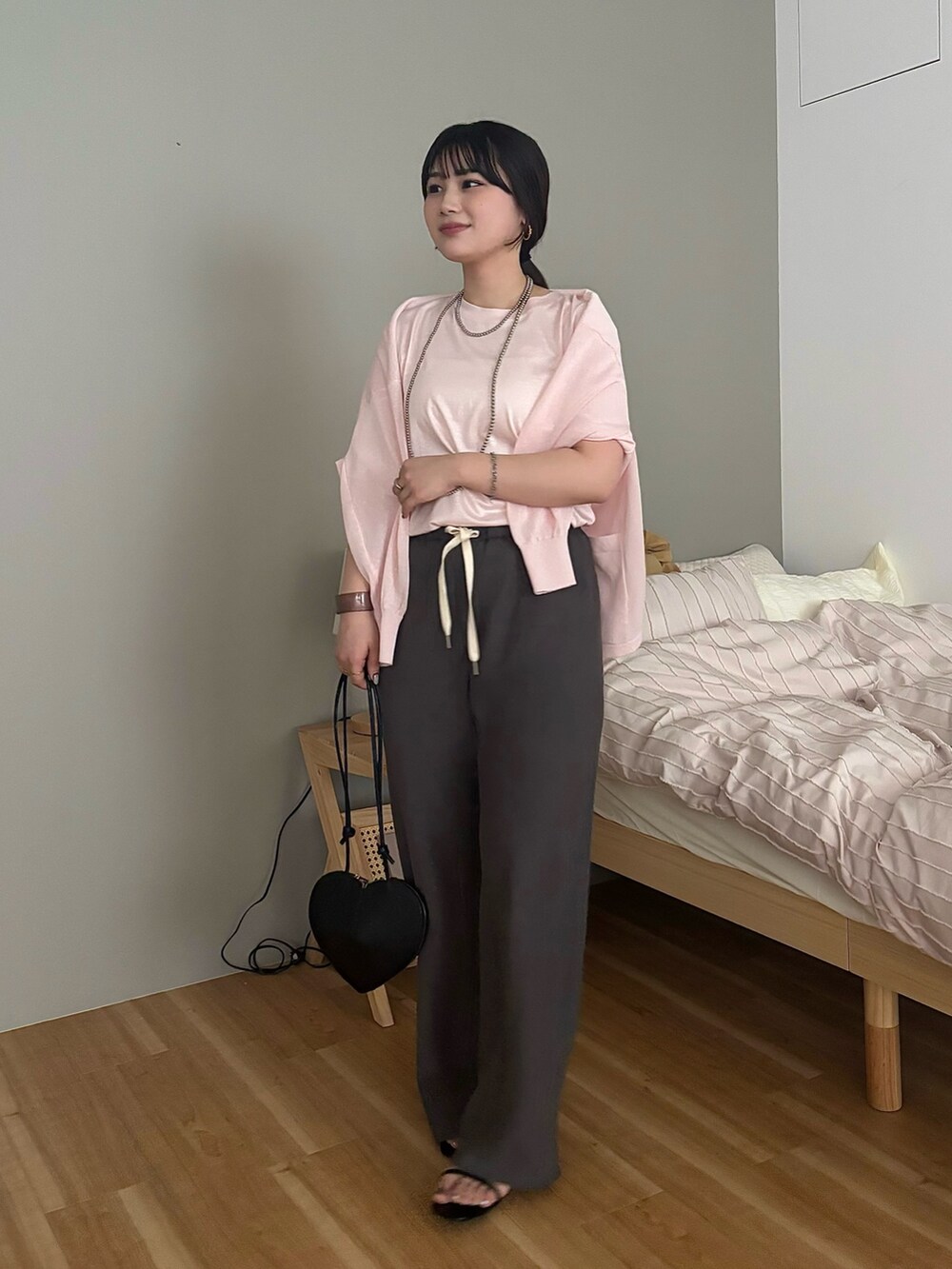 グレー系のその他パンツ、ブラック系のショルダーバッグ、ピンク系のTシャツ/カットソーを着用したレディースの夏コーディネートの4枚目の写真