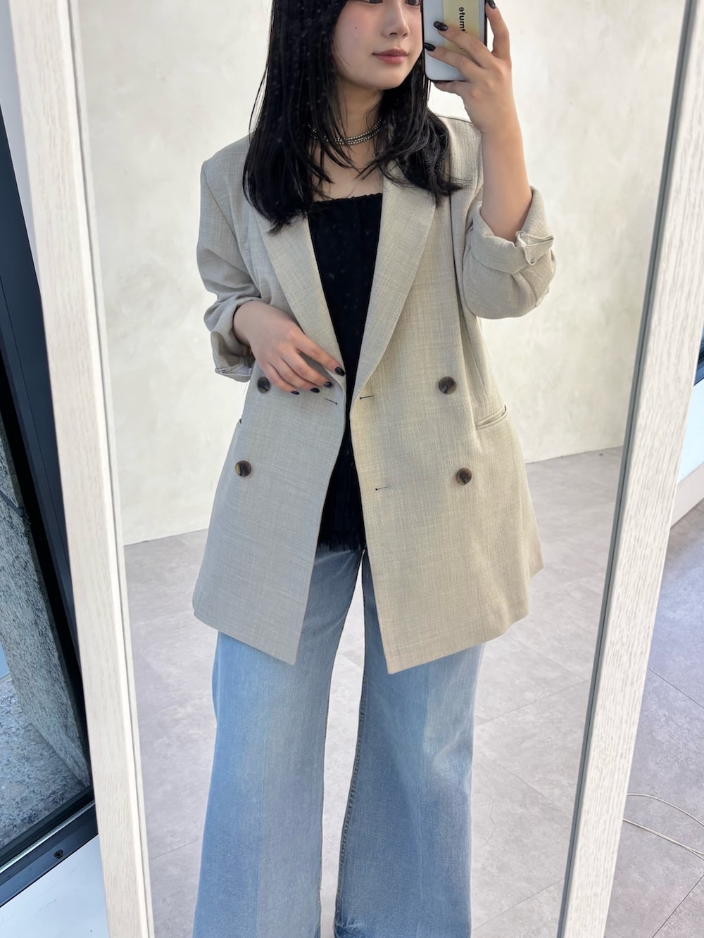 ベージュ系のテーラードジャケット、ブルー系のデニムパンツ、ブラック系のシャツ/ブラウスを着用したレディースの冬コーディネートの2枚目の写真