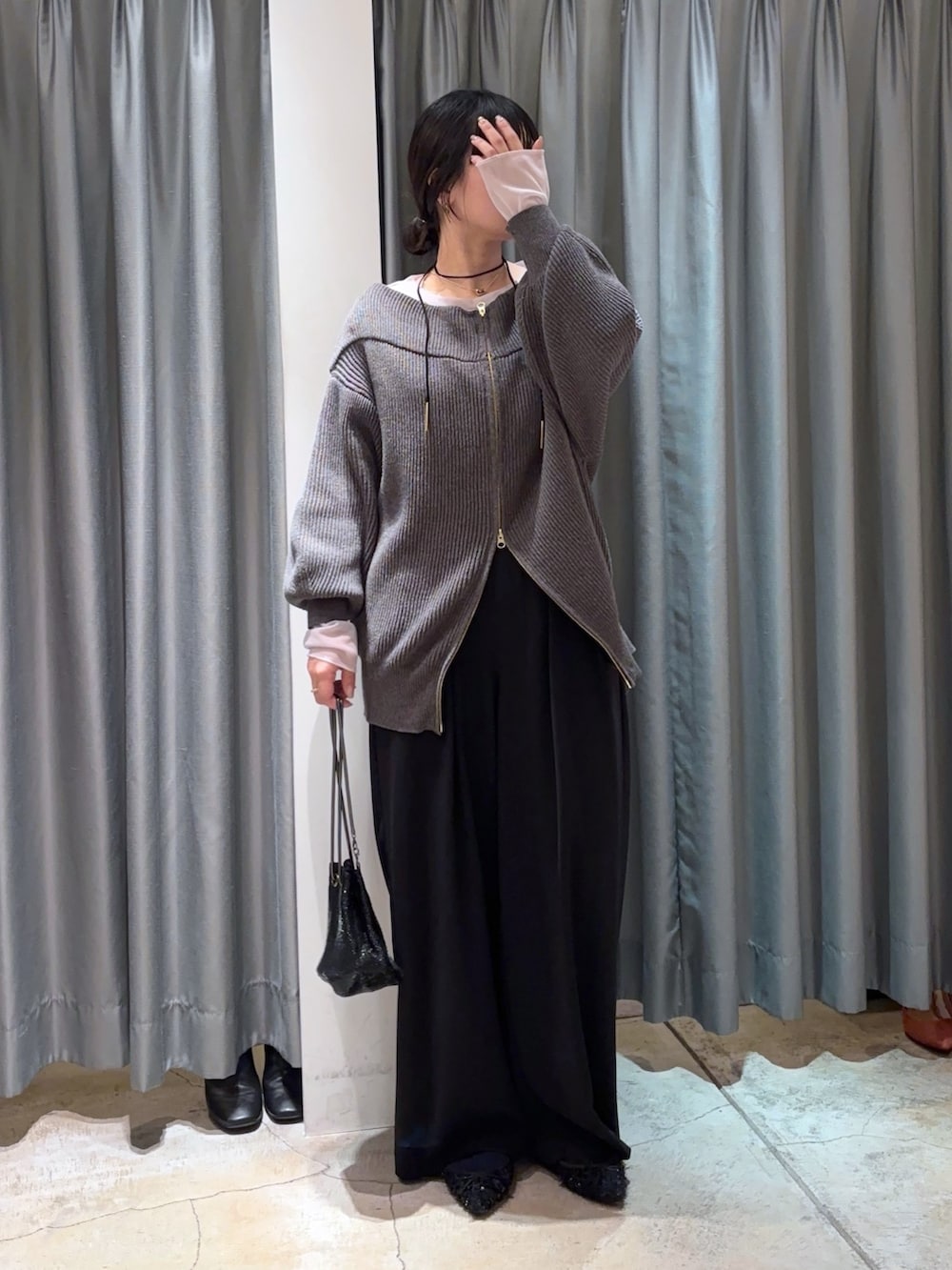 ブラック系のスラックス、グレー系のその他アウター、グレー系のニット/セーターを着用したレディースの冬コーディネートの5枚目の写真