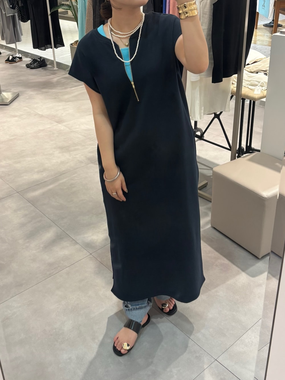 ブルー系のワンピース、ブルー系のデニムパンツ、ブラック系のサンダルを着用したレディースの春コーディネートの2枚目の写真