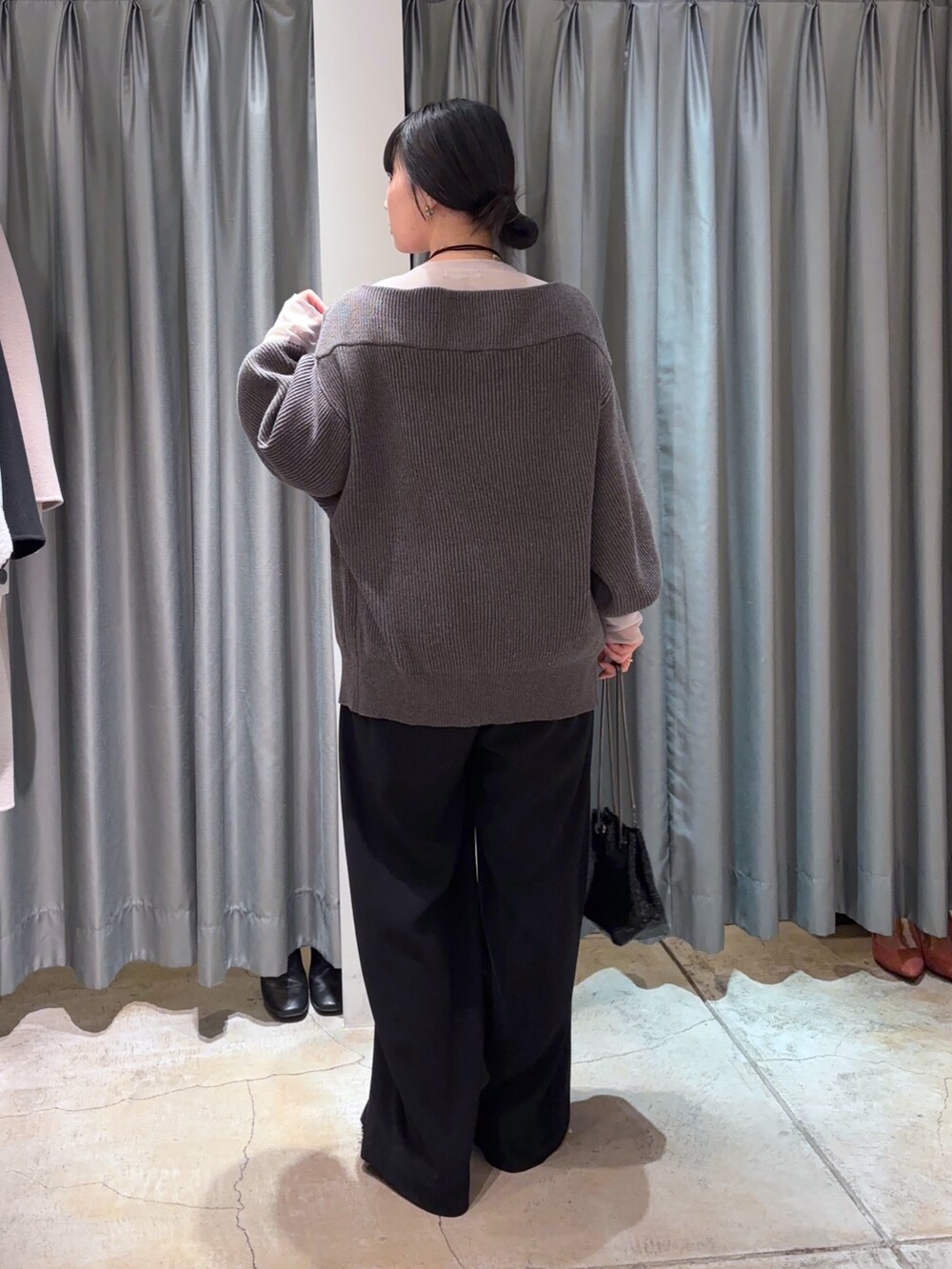 ブラック系のスラックス、グレー系のその他アウター、グレー系のニット/セーターを着用したレディースの冬コーディネートの4枚目の写真