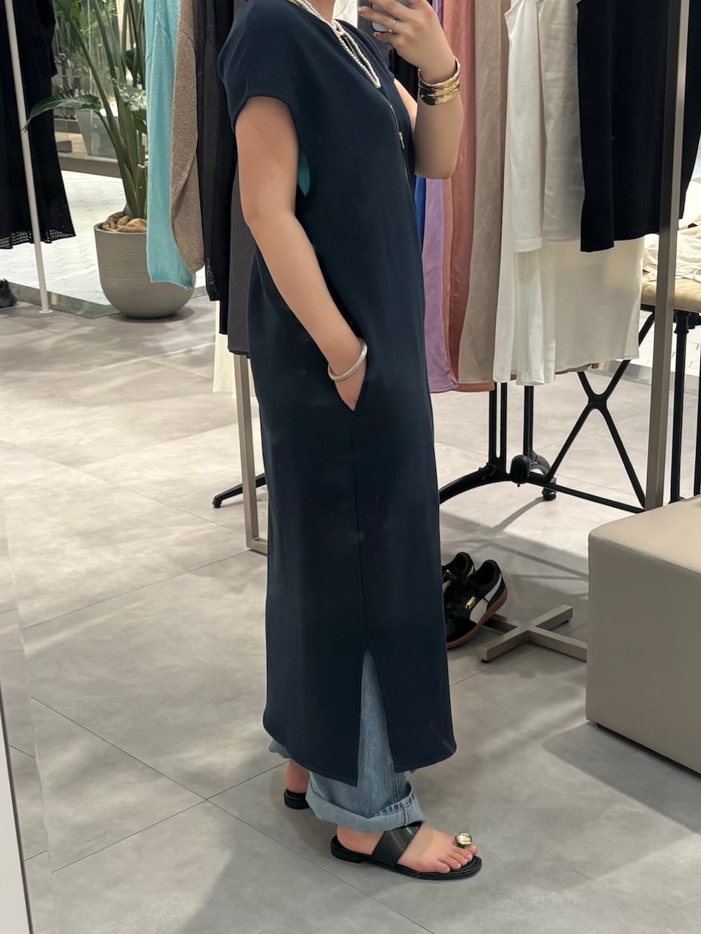 ブルー系のワンピース、ブルー系のデニムパンツ、ブラック系のサンダルを着用したレディースの春コーディネートの4枚目の写真