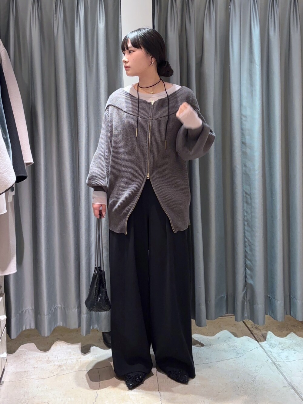 ブラック系のスラックス、グレー系のその他アウター、グレー系のニット/セーターを着用したレディースの冬コーディネートの2枚目の写真