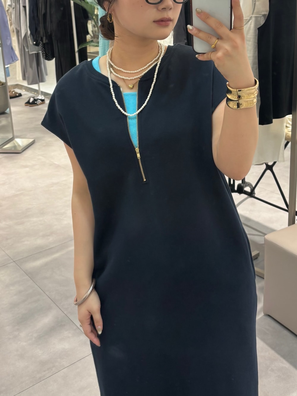 ブルー系のワンピース、ブルー系のデニムパンツ、ブラック系のサンダルを着用したレディースの春コーディネートの3枚目の写真