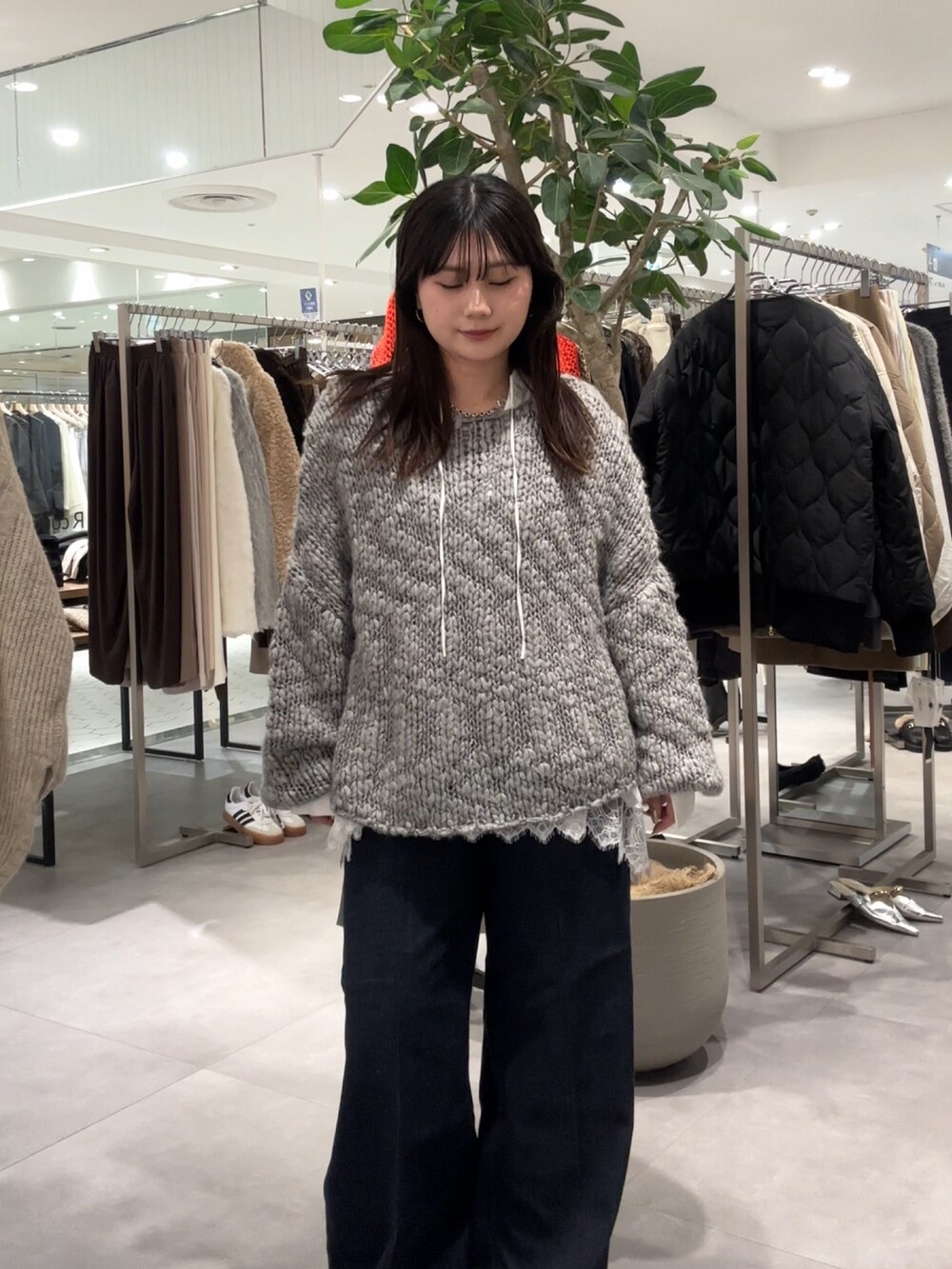 グレー系のニット/セーター、ブラウン系のパンプス、ホワイト系のシャツ/ブラウスを着用したレディースの冬コーディネートの4枚目の写真