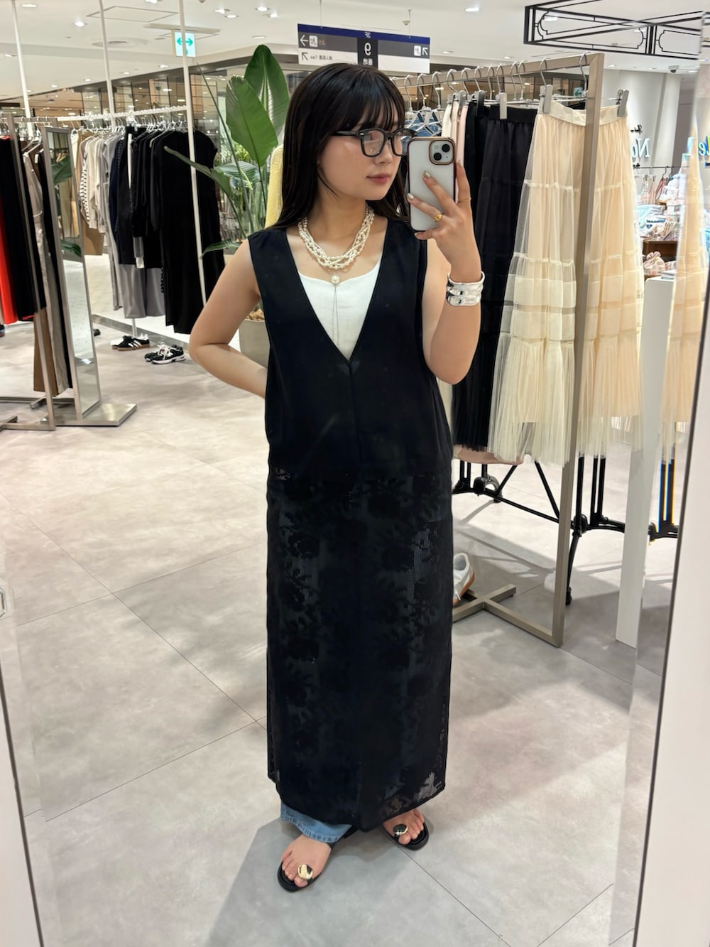 ホワイト系のタンクトップ、ブラック系のワンピース、ブラック系のサンダルを着用したレディースの春コーディネートの4枚目の写真