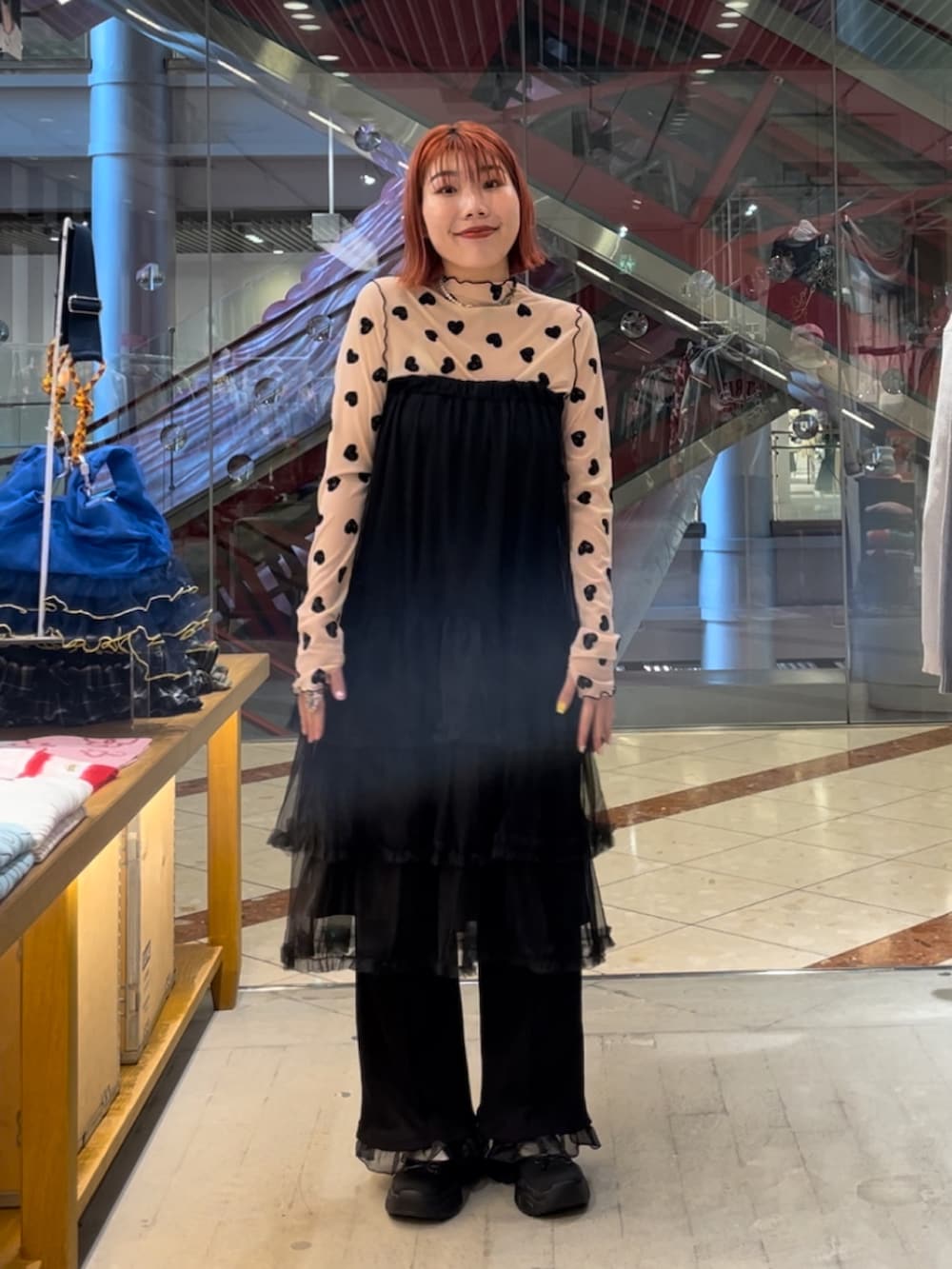 オレンジ系のTシャツ/カットソー、ブラウン系のショルダーバッグ、ホワイト系のその他パンツを着用したレディースの秋コーディネートの2枚目の写真