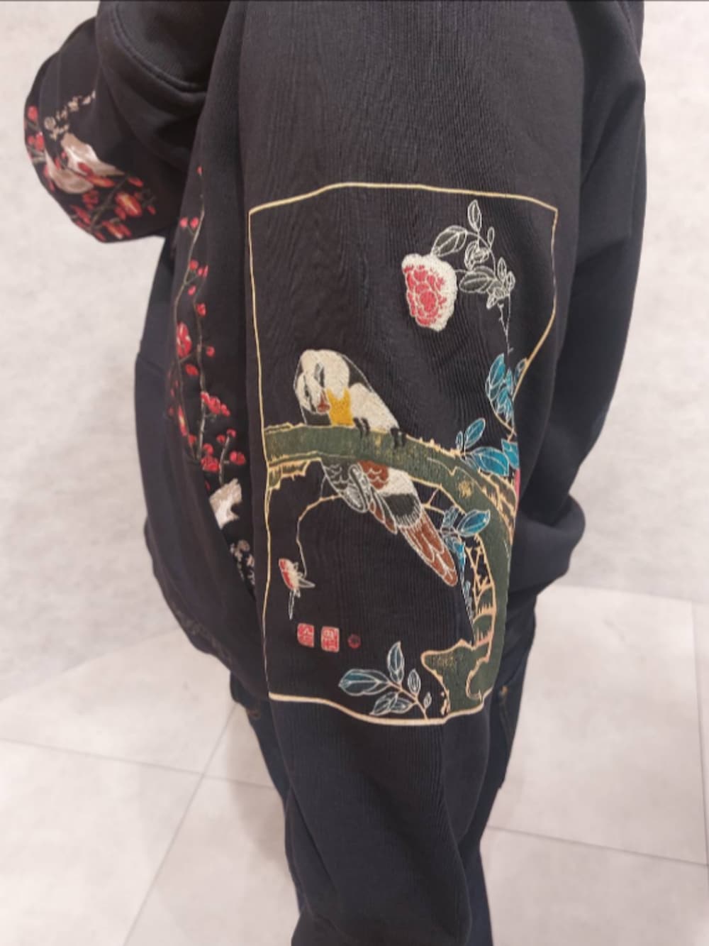 ブラック系のスウェット、ブルー系のデニムパンツ、ブラック系のシューズを着用したメンズの秋コーディネートの3枚目の写真