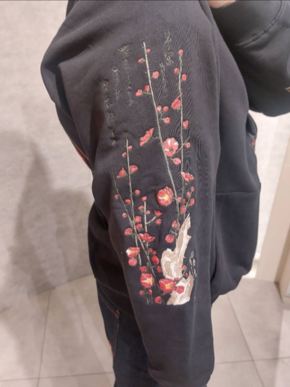 ブラック系のスウェット、ブルー系のデニムパンツ、ブラック系のシューズを着用したメンズの秋コーディネートの4枚目の写真