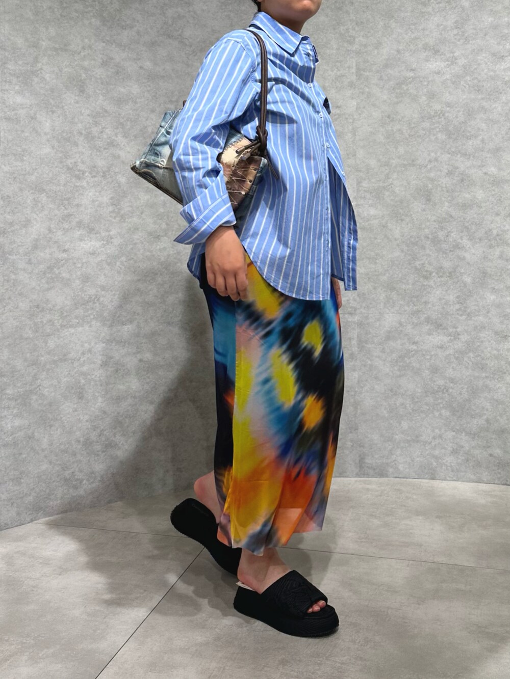 ブルー系のシャツ/ブラウス、ブラック系のスカート、その他のハンドバッグを着用したレディースの春コーディネートの2枚目の写真