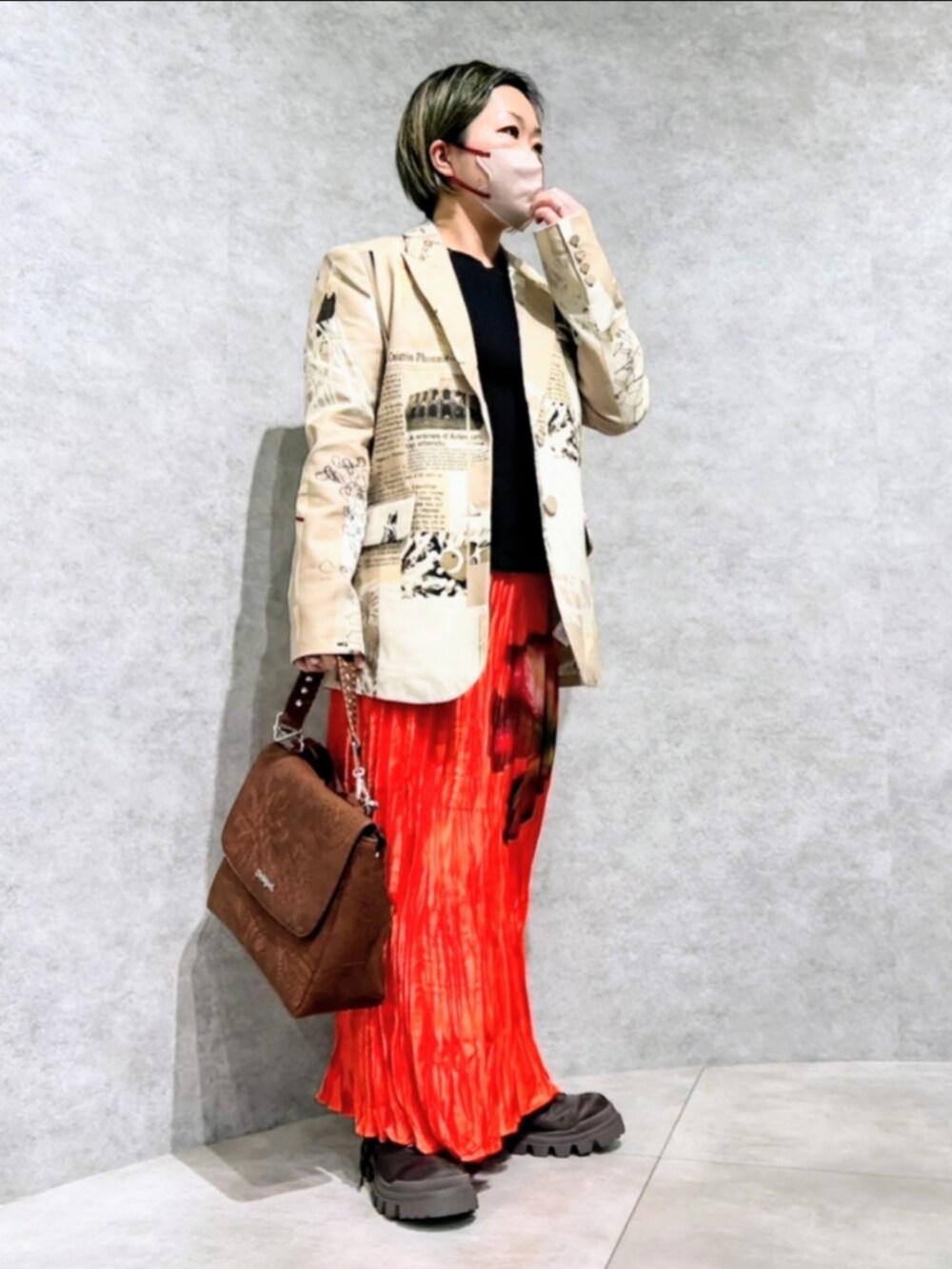 ブラウン系のテーラードジャケット、ブラック系のTシャツ/カットソー、ブラウン系のハンドバッグを着用したレディースの冬コーディネートの2枚目の写真